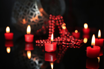 Burning color candles on dark blurred background