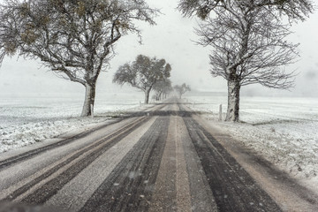 Snow drift and dull light on a winter day cause poor visibility and poor road conditions. Concept: weather or traffic safety © andre