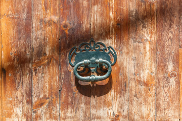 Old iron door handle on a wooden door. Old Iron Door Handle.