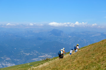 Fototapeta na wymiar Mount Baldo, Italy - August 15, 2017: Walking family climbing the mountain.