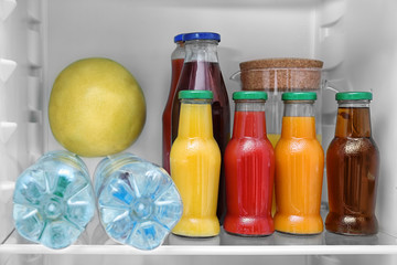 Drinks and fruit on refrigerator shelf, closeup