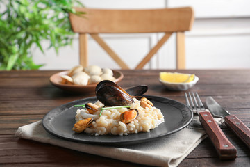 Plate with delicious seafood risotto on table