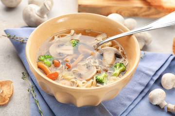 Bowl with mushroom soup on table