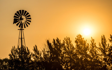 Molino de viento en un atardecer naranja