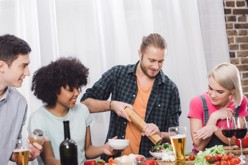 man adding spice to food with pepper grinder