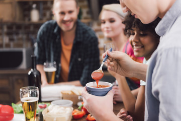cropped image of man taking homemade sauce with spoon