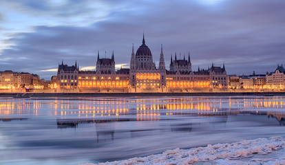 Naklejka premium Winter twilight view of Budapest Parliament building over frozen Danube river