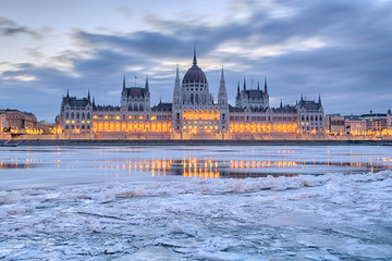 Naklejka premium Zimowy zmierzch widok budynku parlamentu w Budapeszcie nad zamarzniętym Dunajem