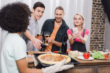 caucasian girl taking photo of african american friends pizza with smartphone
