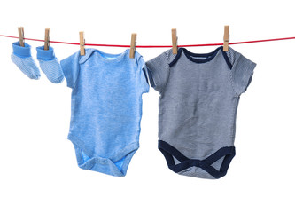 Children's clothes on laundry line against white background