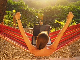 digital nomad girl working in the hammock