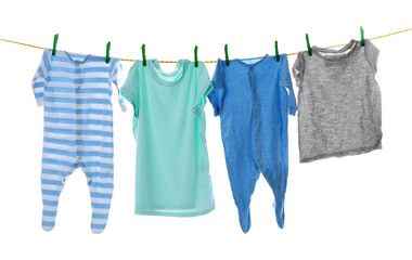 Children's clothes on laundry line against white background