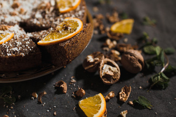 Beautiful and tasty chocolate cake with orange and nut on a dark background