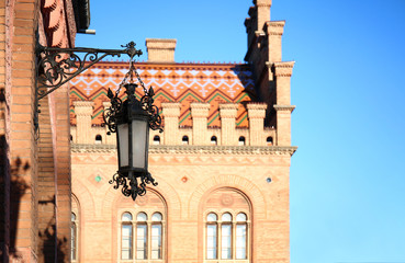 Vintage street lamp on wall of big building