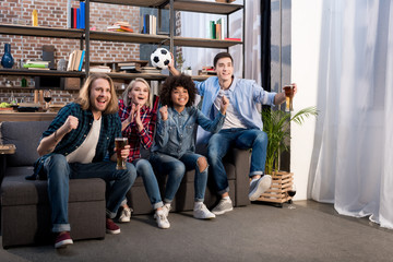 Fototapeta premium multicultural friends watching football with beer at home