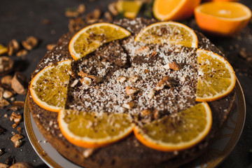 Beautiful and tasty chocolate cake with orange and nut on a dark background