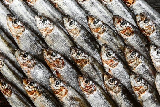 fresh raw fish anchovy and sprat on a wooden surface