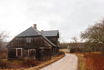 standing at the edge of the road, an old wooden house
