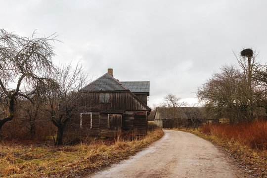 standing at the edge of the road, an old wooden house