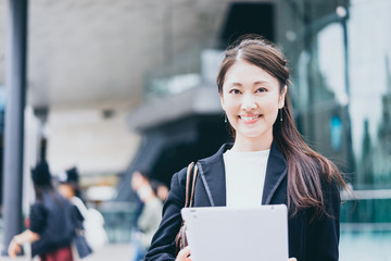 タブレットPCを持つ若い女性（ビジネスイメージ）