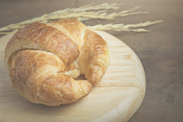 croissant on wood plate.