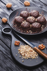 delicious mini chocolate cakes with walnut on a black wooden table