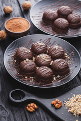 delicious mini chocolate cakes with walnut on a black wooden table