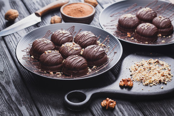 delicious mini chocolate cakes with walnut on a black wooden table