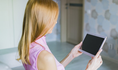 Woman at home relaxing reading on the tablet 