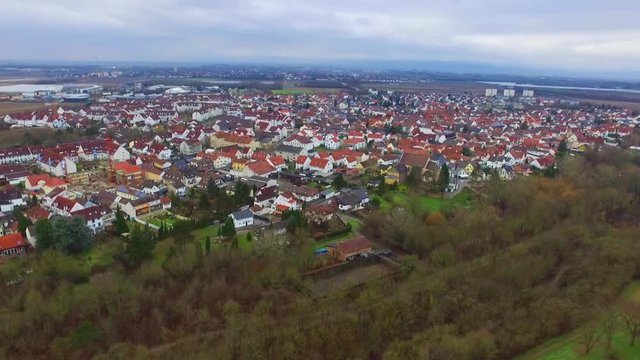 Stunning aerial 4k drone flight over calm small city cityscape with big mirror surface lake in park on cloudy day