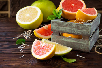 Fresh and juicy red grapefruit and pomelo on a wooden table. Still life, diet and nutrition concept.