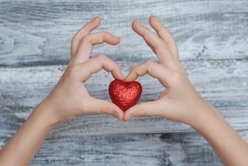 Hands Holding Red Heart, Relationship and LOVE concept - close up of Hand Showing Red Heart on Gray Wooden background