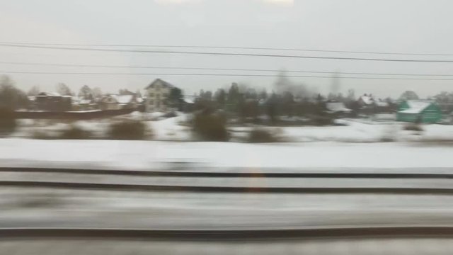 High angle View from the window of a high-speed train on the old village and frozen river