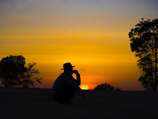 Silhouette of man smoking in the sunset golden hour.