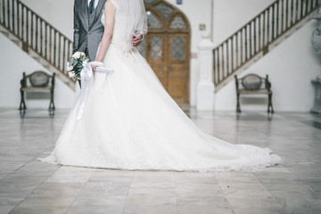 Naklejka na ściany i meble Bride and groom in luxury wedding dress holding together