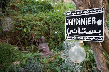Peaceful retreat in a garden / Garden with buddha statue and sign that says 