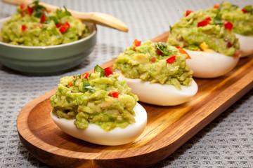 Healthy breakfast - eggs stuffed with guacamole with coriander and chili