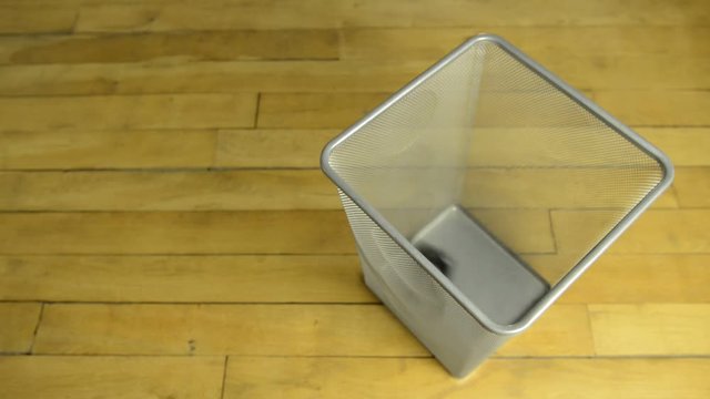 Dumping into metal basket collection of used, disposable cameras. Old wooden parquet floor in background.
 - Powered by Adobe