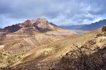 Fototapeta na wymiar Rainbow over Mountain landscape of Gran Canaria island, Spain / Valley of 
