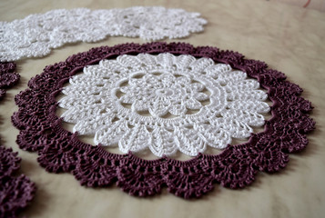 White and purple hand hooked coaster. Knitted holders for hot work