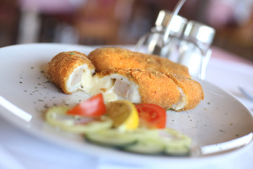 Fried perch fillet served with tomato, onion, lemon and cucumbers.