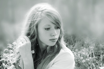 black and white with a toning portrait of a young girl, straightening her hair and looking to the side