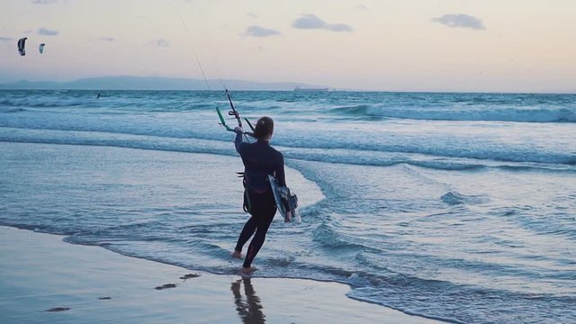 The kite-surfing surfer sails on the ocean wave. Maldives. Slow motion