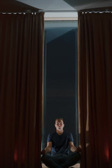 dark room, the boy is doing yoga