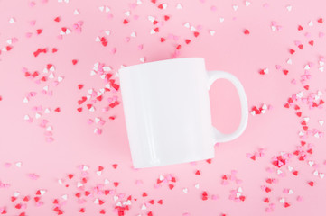 white mug on a pink background with hearts