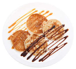 Serving pancakes with chocolate syrup and caramel syrup. Isolated on white background. Top view.