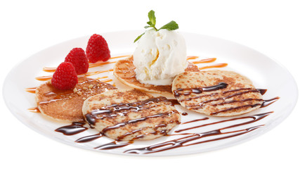 Serving pancakes with ice cream on the plate. Decorated with chocolate syrup, caramel syrup, fresh...