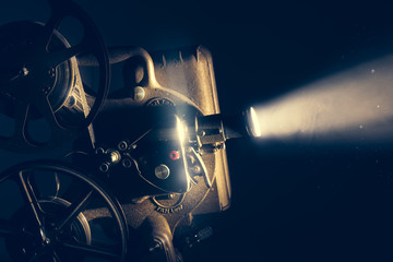 Film projector with dramatic lighting , high contrast image - obrazy, fototapety, plakaty