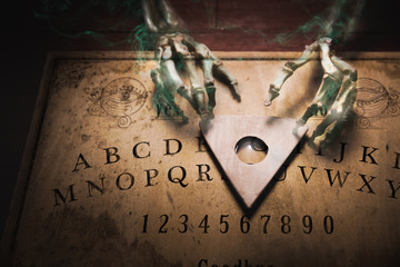 Talking board with a ghost touching the planchette, high contrast image