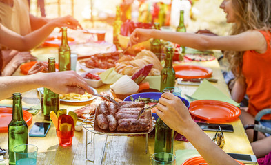 Group of friends eating dinner at barbecue party outdoor in nature